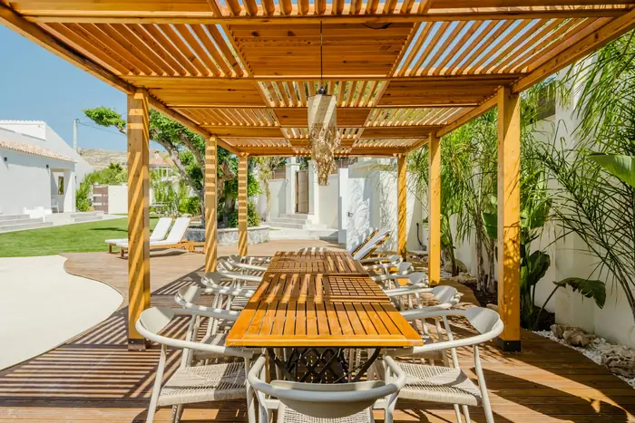 Foto van een verzorgd terras onder een pergola